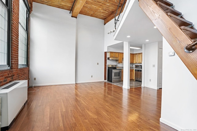 25 Grand St Apt 102, Norwalk, CT 06851 - unfurnished living room featuring light wood finished floors, wood ceiling with exposed beams, recessed lighting, and baseboards