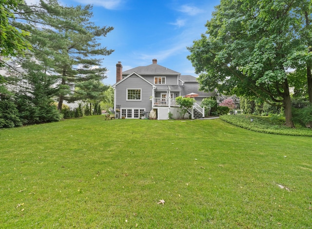 28 Eagle Dr, Fairfield, CT 06825 - rear view of house with a chimney, a yard, stairway, and a deck