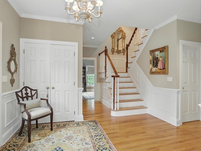 28 Eagle Dr, Fairfield, CT 06825 - entryway featuring light wood-style flooring, a decorative wall, a chandelier, ornamental molding, and stairs