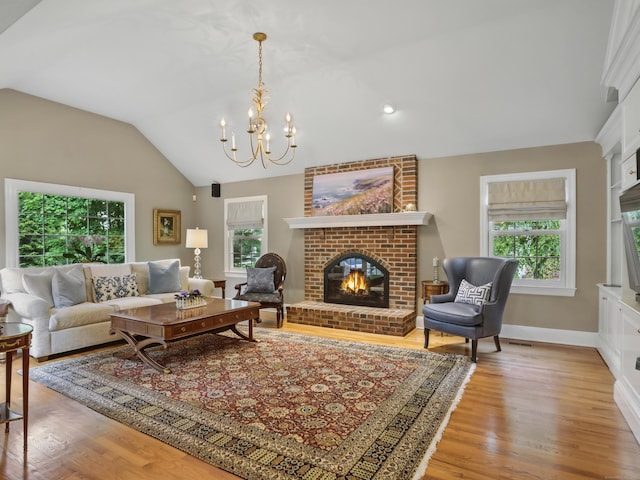 28 Eagle Dr, Fairfield, CT 06825 - living room with lofted ceiling, a brick fireplace, light wood-style flooring, a chandelier, and baseboards