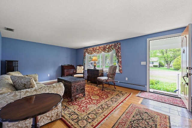 154 Sims Rd, Bristol, CT 06010 - living room with a baseboard radiator, light wood-style flooring, and a textured ceiling