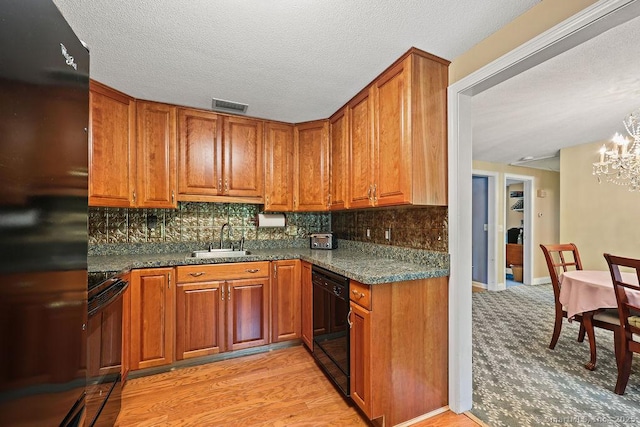 154 Sims Rd, Bristol, CT 06010 - kitchen with black appliances, a sink, a chandelier, brown cabinets, and a textured ceiling