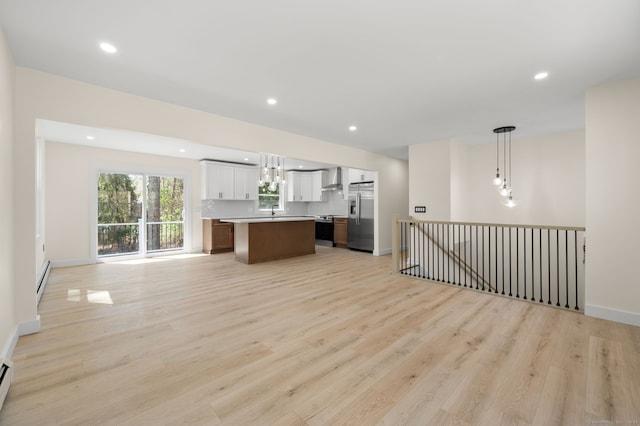 132 Bailey Pond Rd, Voluntown, CT 06384 - kitchen with appliances with stainless steel finishes, open floor plan, wall chimney exhaust hood, a center island, and light wood finished floors