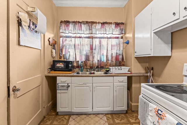 245 Ledyard St, New London, CT 06320 - kitchen featuring white range with electric stovetop, a sink, and white cabinetry