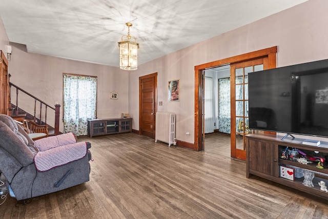 245 Ledyard St, New London, CT 06320 - living room with radiator, a chandelier, wood finished floors, and stairs