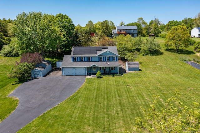 10 Spoonville Rd, East Granby, CT 06026 - traditional-style house with covered porch, asphalt driveway, a front lawn, and roof mounted solar panels