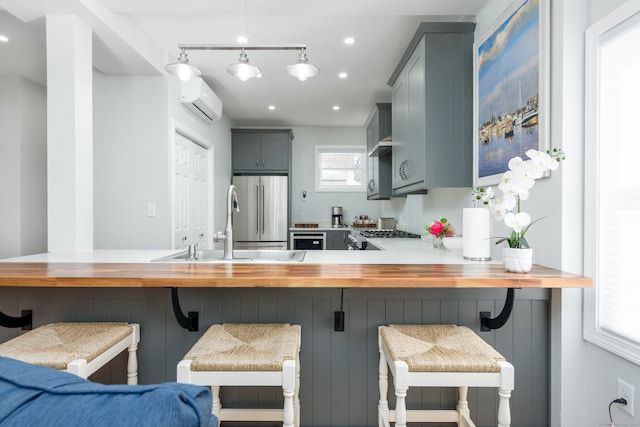 276 Niantic River Rd, Waterford, CT 06385 - kitchen with an AC wall unit, high end fridge, a peninsula, a breakfast bar area, and recessed lighting
