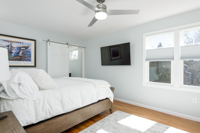 276 Niantic River Rd, Waterford, CT 06385 - bedroom with multiple windows, wood finished floors, ceiling fan, and a barn door