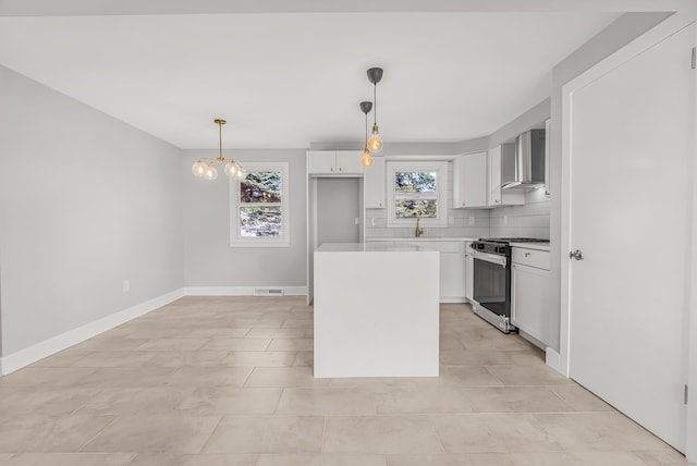 261 High St, Fairfield, CT 06824 - kitchen featuring gas stove, wall chimney exhaust hood, a chandelier, white cabinetry, and backsplash
