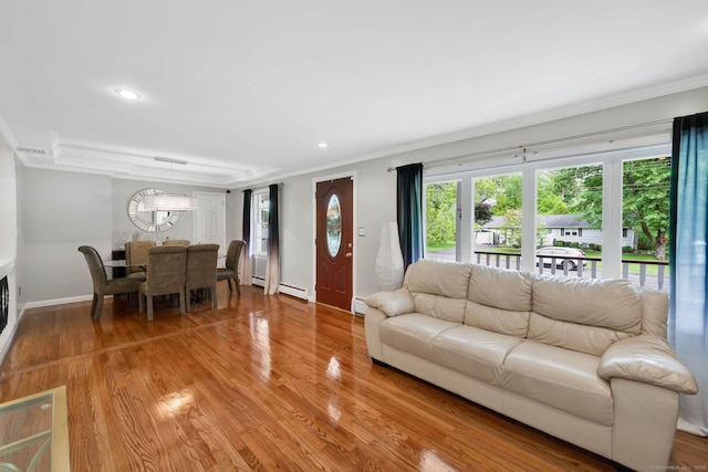 living area featuring light wood-style floors, baseboards, recessed lighting, baseboard heating, and ornamental molding