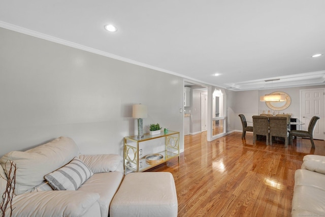 living room with ornamental molding, light wood finished floors, recessed lighting, and baseboards