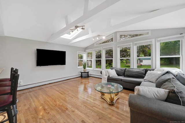 living room featuring a skylight, light wood finished floors, and a baseboard radiator