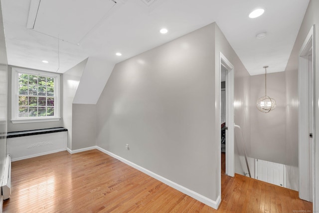 additional living space featuring attic access, light wood finished floors, baseboards, and recessed lighting