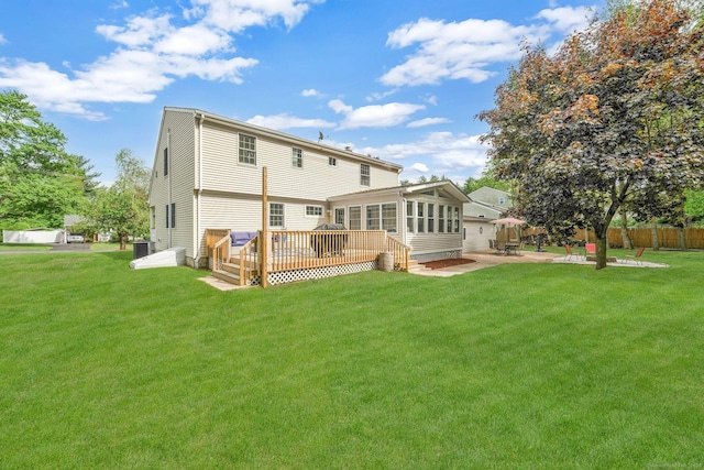 back of house featuring a wooden deck, a sunroom, and a patio