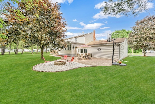 rear view of house featuring a fire pit, a lawn, a patio, and a chimney