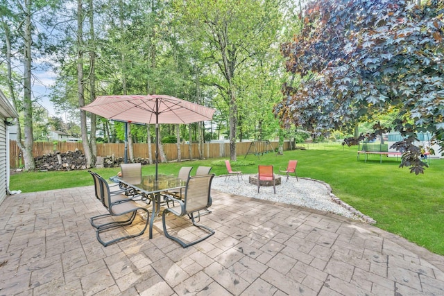 view of patio / terrace with a trampoline, an outdoor fire pit, and outdoor dining space