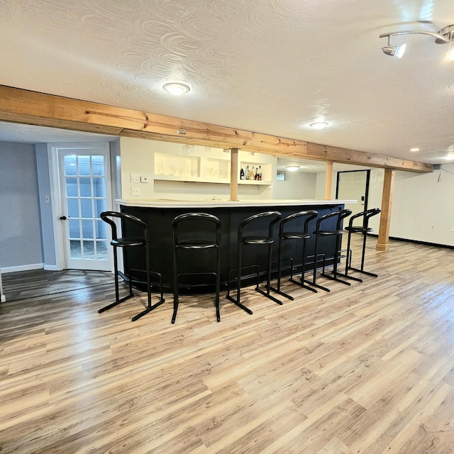 kitchen with light wood-style flooring, baseboards, and a breakfast bar area