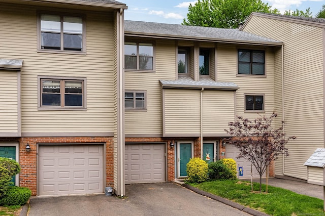 85 Metacomet Dr Unit 85, Meriden, CT 06450 - multi unit property with driveway, a garage, brick siding, and a shingled roof