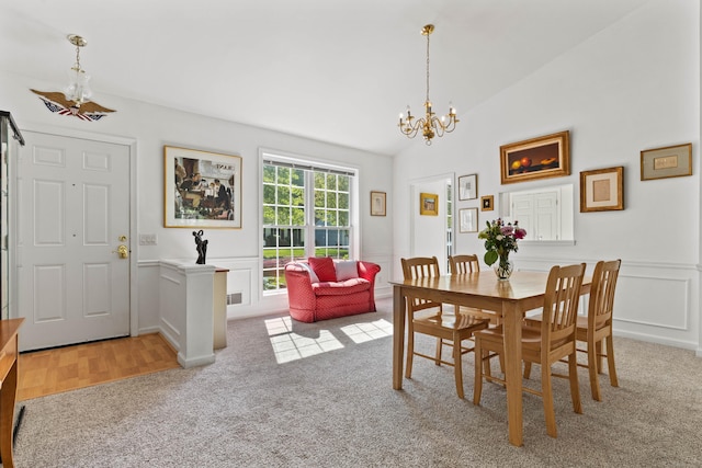 8 Cypress Way, Waterford, CT 06385 - dining area with a chandelier, light colored carpet, vaulted ceiling, a wainscoted wall, and a decorative wall