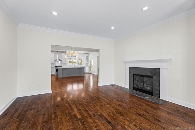 unfurnished living room with a fireplace, dark wood-style flooring, ornamental molding, a chandelier, and baseboards