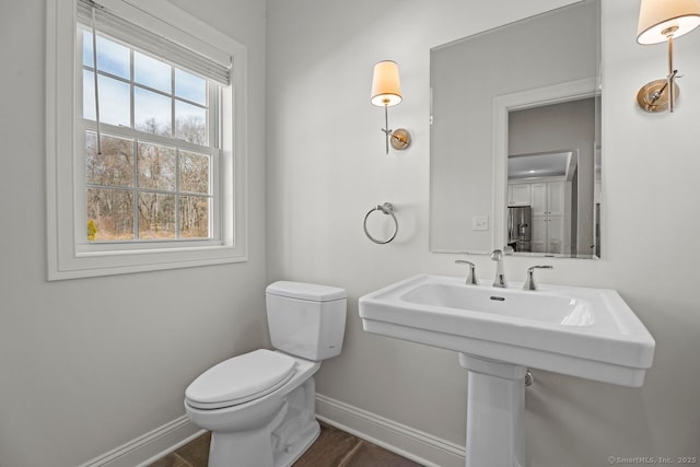 bathroom featuring baseboards and toilet