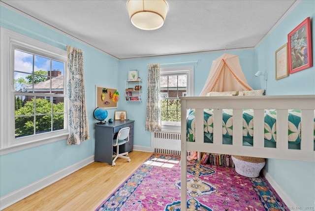 bedroom with wood finished floors and baseboards