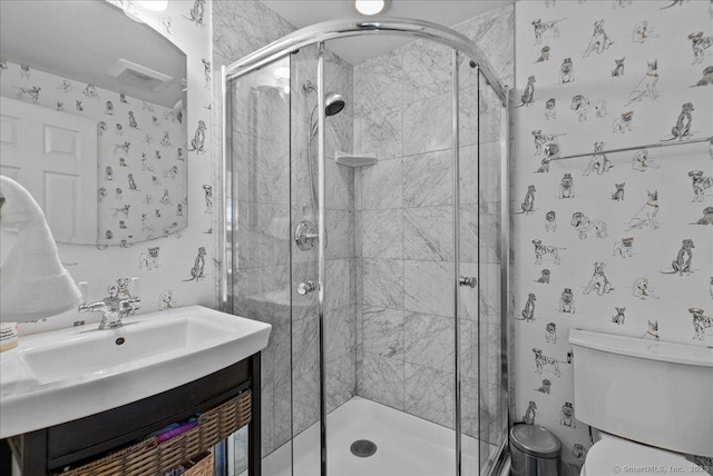 bathroom with toilet, a shower stall, and vanity