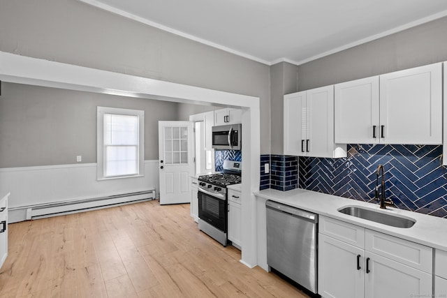 69 Trinity St, New Britain, CT 06051 - kitchen with stainless steel appliances, a baseboard radiator, a sink, light countertops, and white cabinets