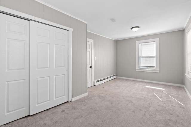 69 Trinity St, New Britain, CT 06051 - unfurnished bedroom with baseboard heating, crown molding, carpet floors, baseboards, and a closet