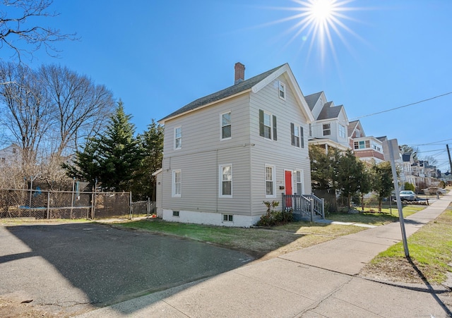69 Trinity St, New Britain, CT 06051 - view of property exterior with fence, a chimney, and a residential view