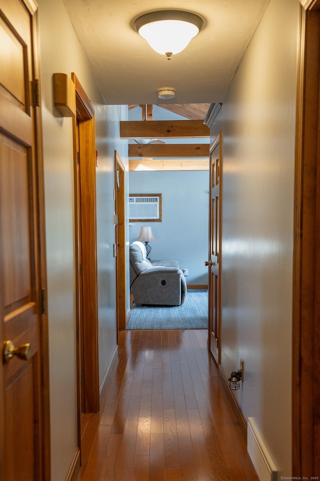 corridor with dark wood-style floors, lofted ceiling, baseboards, and a wall mounted air conditioner