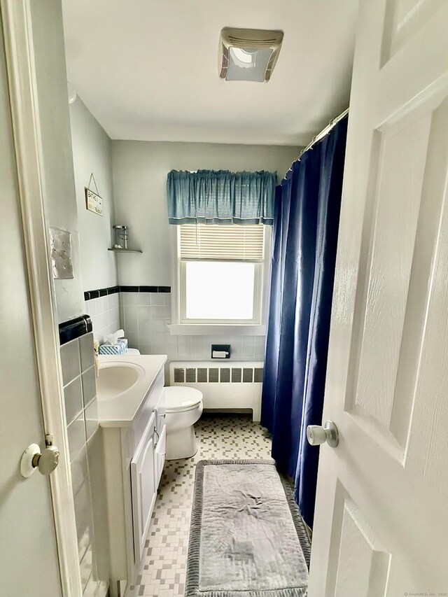 260 W Center St, Southington, CT 06489 - full bathroom with radiator heating unit, tile walls, toilet, vanity, and a wainscoted wall