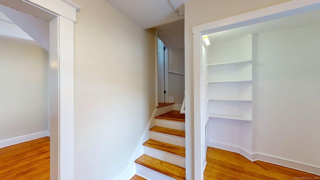 stairway featuring wood finished floors and baseboards