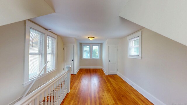 bonus room with light wood-type flooring and baseboards
