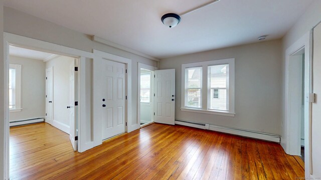 entrance foyer with a baseboard heating unit and light wood-style flooring