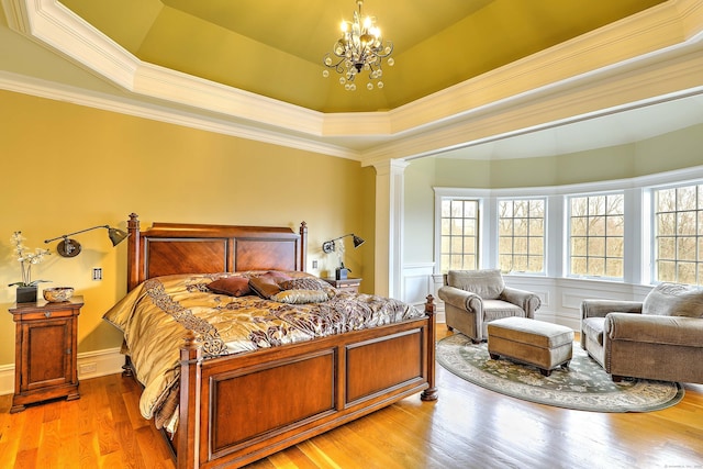 84 Mustang Dr, Monroe, CT 06468 - bedroom featuring multiple windows, ornate columns, a chandelier, ornamental molding, and light wood-style flooring