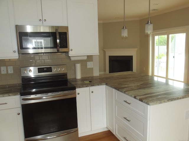 94 Stonehouse Rd Unit 16, Coventry, CT 06238 - kitchen featuring stainless steel appliances, ornamental molding, a peninsula, decorative backsplash, and white cabinets