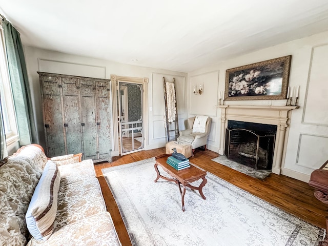 49 Bennett Pond Rd, Canterbury, CT 06331 - living area with a fireplace with flush hearth, wood finished floors, and a decorative wall
