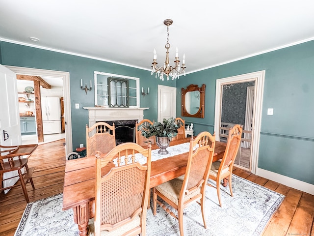 49 Bennett Pond Rd, Canterbury, CT 06331 - dining space with a chandelier, crown molding, hardwood / wood-style flooring, a fireplace, and baseboards