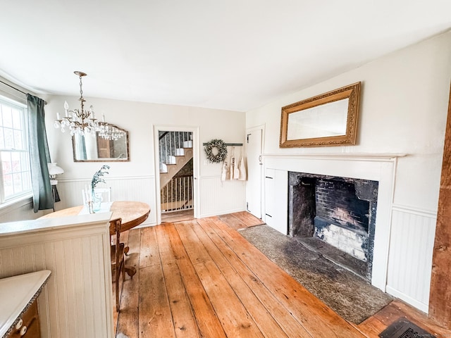 49 Bennett Pond Rd, Canterbury, CT 06331 - dining area featuring light wood finished floors, wainscoting, a chandelier, a premium fireplace, and stairway