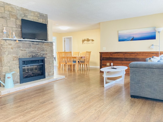 67 S Beechwood Rd, East Lyme, CT 06357 - living room with wood finished floors, a fireplace, baseboards, and a textured ceiling