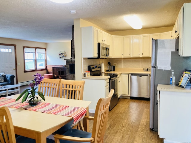 67 S Beechwood Rd, East Lyme, CT 06357 - kitchen with stainless steel appliances, light wood-style flooring, light countertops, tasteful backsplash, and a textured ceiling