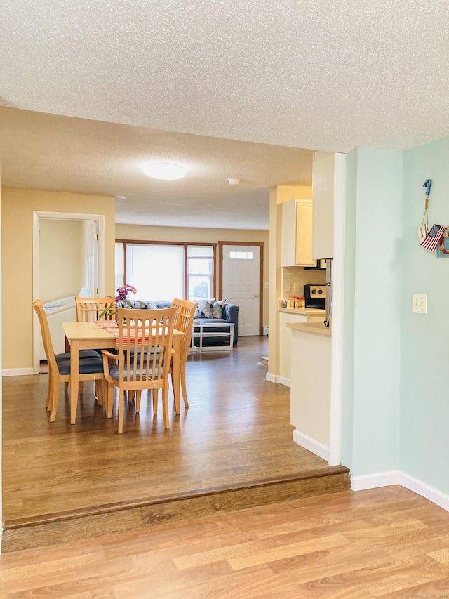 67 S Beechwood Rd, East Lyme, CT 06357 - dining space with light wood finished floors, baseboards, and a textured ceiling