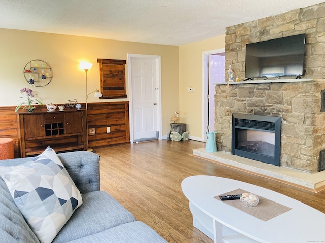 67 S Beechwood Rd, East Lyme, CT 06357 - living room featuring wood finished floors, a fireplace, and a textured ceiling