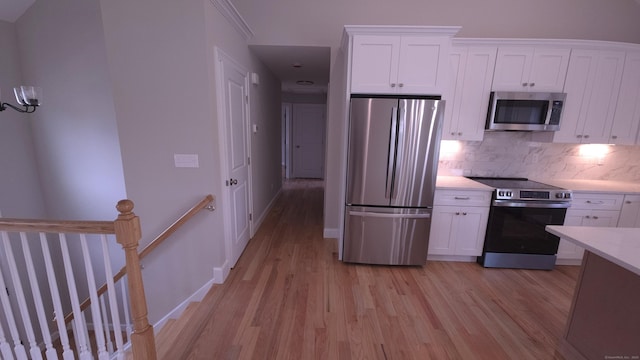40 Yorktown Rdg, Waterbury, CT 06704 - kitchen featuring appliances with stainless steel finishes, light wood-style flooring, backsplash, and white cabinetry