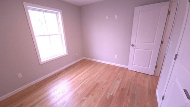 40 Yorktown Rdg, Waterbury, CT 06704 - unfurnished bedroom featuring multiple windows, light wood-style floors, and baseboards
