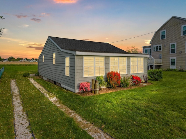 74 Chalker Beach Rd, Old Saybrook, CT 06475 - back of house at dusk with a lawn and roof with shingles
