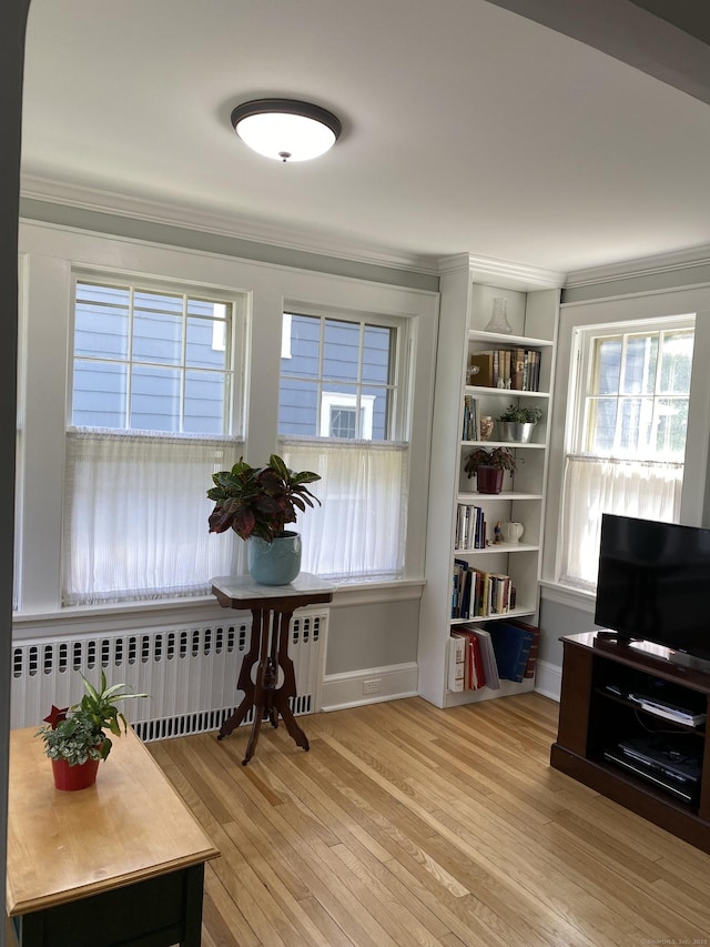 1248 Valley Rd, Fairfield, CT 06825 - living area with radiator heating unit, wood finished floors, healthy amount of natural light, crown molding, and baseboards