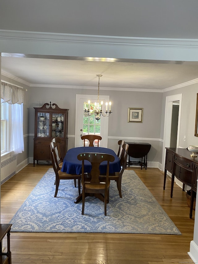 1248 Valley Rd, Fairfield, CT 06825 - dining space featuring radiator, a chandelier, plenty of natural light, wood finished floors, and crown molding
