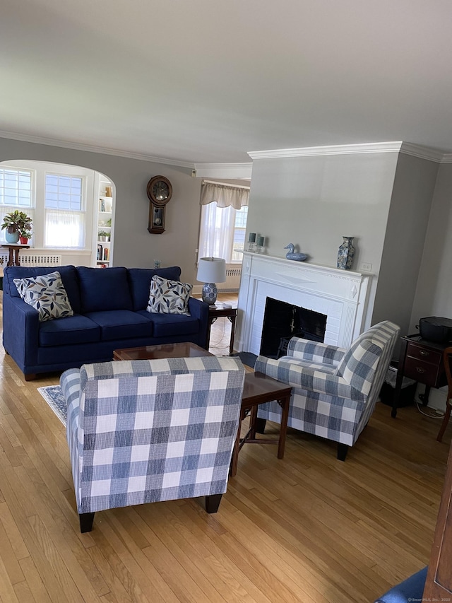 1248 Valley Rd, Fairfield, CT 06825 - living room featuring ornamental molding, light wood-style flooring, a brick fireplace, and arched walkways